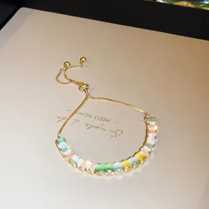 Detailed shot of gold adjustable bracelet with multi-colored rectangular zircon stones