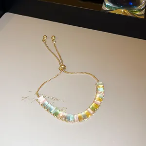 Close-up of adjustable gold-tone bracelet with colorful rectangular cubic zirconia
