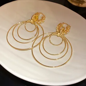 Close-up of elegant gold multi-layer concentric hoop earrings with sparkling rhinestones