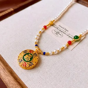 Primo piano di una collana di perle neo-cinese placcata oro con ciondolo portafortuna