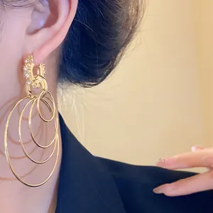 Detailed view of golden multi-layered hoop earrings with sparkling rhinestone accents.