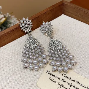 Vintage-style silver needle earrings with rhinestones and faux pearl tassels in elegant design.