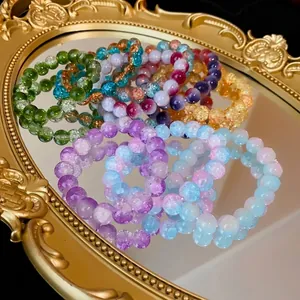 Bracciali elastici in perle di vetro crackle sfumate su uno specchio dorato vintage