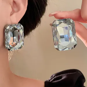Macro view of large rectangular faceted crystal earrings showing sparkle and French retro style