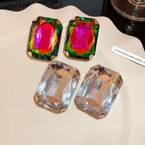 Close-up of oversized rectangular crystal stud earrings in multicolor and clear styles
