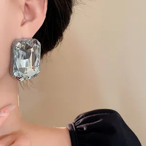 Close-up of oversized rectangular faceted crystal earring with French vintage style.