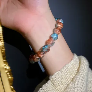 Dettaglio di un elegante braccialetto elastico in perle di vetro craquelé sfumate al polso