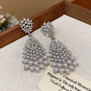Detailed view of elegant silver chandelier earrings with pearls and rhinestones