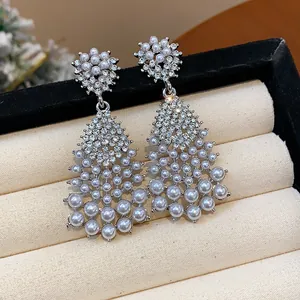 Detail of vintage silver earrings with rhinestones and white pearls in box