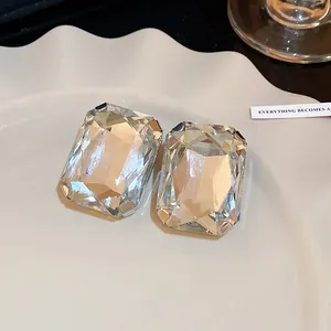 Close-up of vintage-style clear rectangular crystal earrings on a white plate