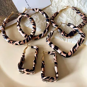 Detailed macro view of stylish leopard print leather wrapped geometric hoop earrings set