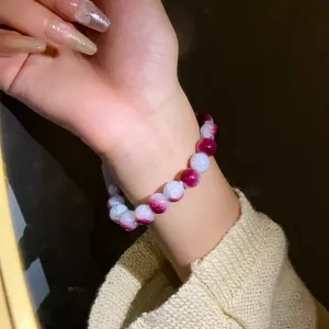 Primo piano del braccialetto elastico con perle di vetro craquelé sfumate viola e bianco