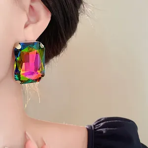 Detailed view of large rectangular rainbow crystal earring on model