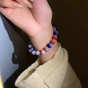Dettaglio di un elegante bracciale elastico in perline di vetro screpolato sfumato sul polso