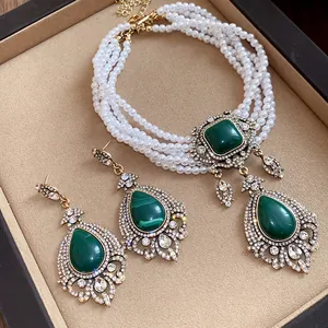 Détail d'un collier de perles vintage à plusieurs rangs avec pierres vertes et boucles
