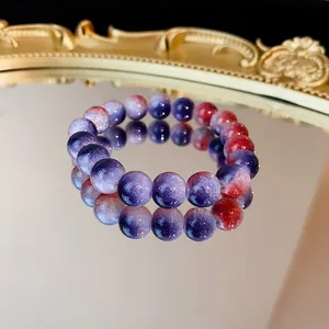 Dettaglio di bracciale in perle di vetro cracklé su una superficie a specchio