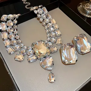 Detailed macro view of oversized heart and teardrop crystal necklace with matching earrings