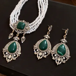 Détail d'un collier de perles vintage et boucles d'oreilles en pierre précieuse verte