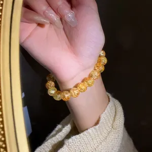 Vista dettagliata di un elegante braccialetto elastico con perle in vetro crackle.