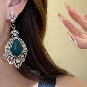 Vue détaillée d'une boucle d'oreille vintage de style palais avec pierre verte