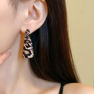 Close-up of leopard print wrap-around leather earring on model's ear