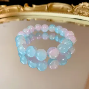Vista dettagliata delle perle di vetro sfumate rosa e blu su un bracciale elastico