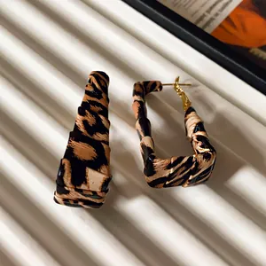 Detail view of geometric hoop earrings wrapped in stylish leopard print leather