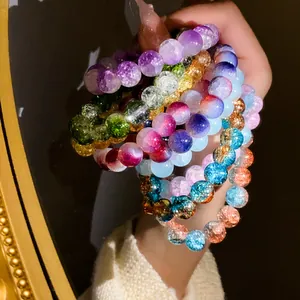 Dettaglio macro di braccialetti con perline di vetro crepato sfumato e colori vivaci.