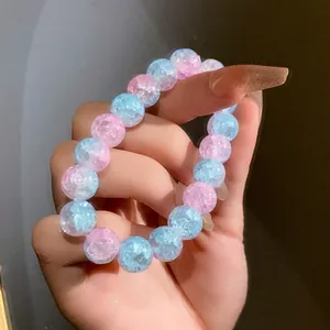 Primo piano di un bracciale elastico con perle di vetro crepato rosa e blu