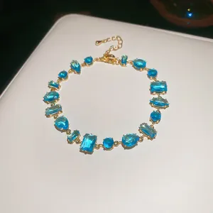 Elegante pulsera dorada ajustable con vibrantes piedras de circonita cúbica azul geométrica