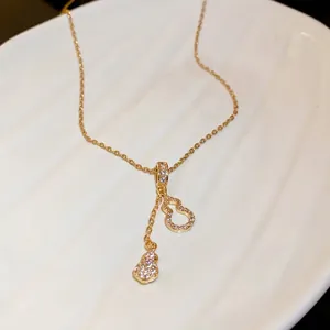 Elegant gold stainless steel necklace with crystal pavé hulu gourd tassel pendants.