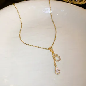 Detailed view of elegant gold stainless steel necklace featuring zircon-encrusted gourd tassels.