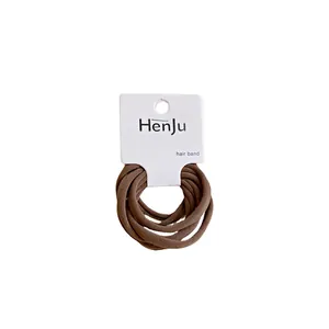 Lot de dix élastiques à cheveux marrons en tissu hautement élastique sur carte blanche.
