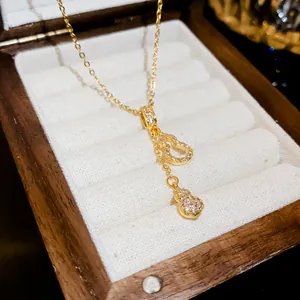 Macro view of gold stainless steel hulu tassel necklace featuring sparkling zircon stones
