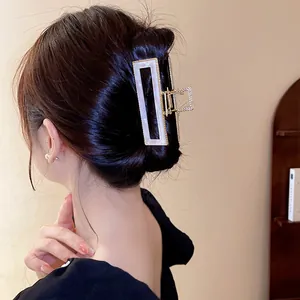 Gros plan d'une pince à cheveux en acétate nacré sirène portée sur un chignon chic
