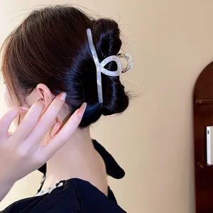 Pince à cheveux élégante en acétate blanc irisé montrée sur un chignon de mannequin pro.