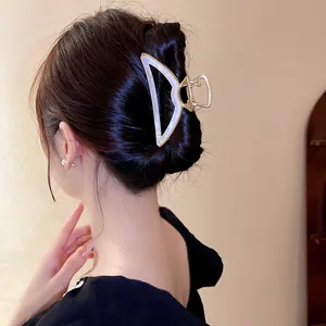 Pince à cheveux élégante en acétate nacré présentée sur un chignon classique pour femme