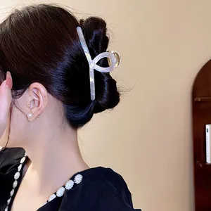 Gros plan d'une pince à cheveux en acétate irisé coiffée dans un chignon classique.
