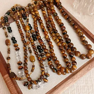 Detailansicht von Vintage-Tigerauge-Halsketten mit Kristallperlen in einem Tablett