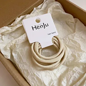 Lot d'élastiques à cheveux beiges minimalistes en tissu sur carte de marque