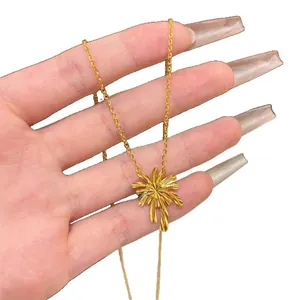 Elegant 24k gold plated palm tree pendant necklace held in hand for jewelry display