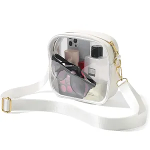 Clear PVC crossbody bag with white strap shown containing sunglasses and makeup