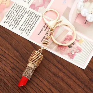 Elegante portachiavi a forma di rossetto dorato con strass scintillanti e punta rossa