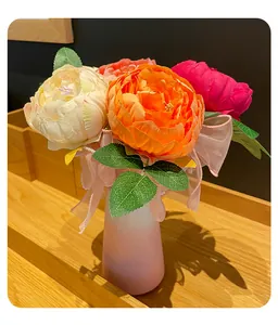 Close-up of creative artificial peony flower pens with a pink decorative ribbon