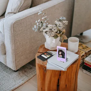 Nahaufnahme von Mini-Instax-Fotorahmen in Schwarz und Lila auf einem rustikalen Holztisch