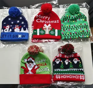 Five colorful LED light-up Christmas beanie hats in individual plastic packaging.