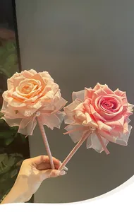 Detailansicht eleganter rosafarbener Kugelschreiber in Rosenform mit Spitzenakzenten.