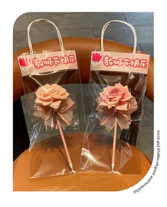 Detailed view of pink rose ballpoint pens in elegant transparent gift packaging bags.