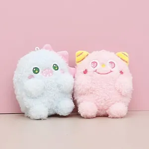 Close-up view of two mini plush monster and cat dolls in light blue and pink colors