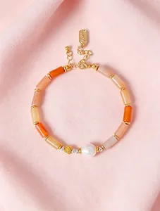 Detail view of bamboo-style Jinsiyu stone beads and pearl on a golden bracelet.
